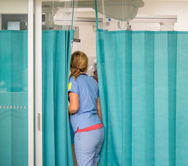 nurse moving through hospital cubical curtains