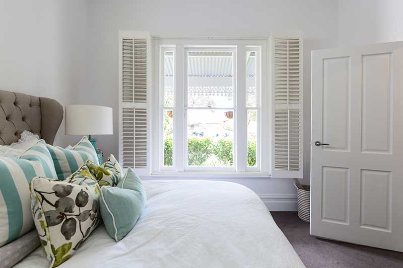 white shutters on window in bedroom